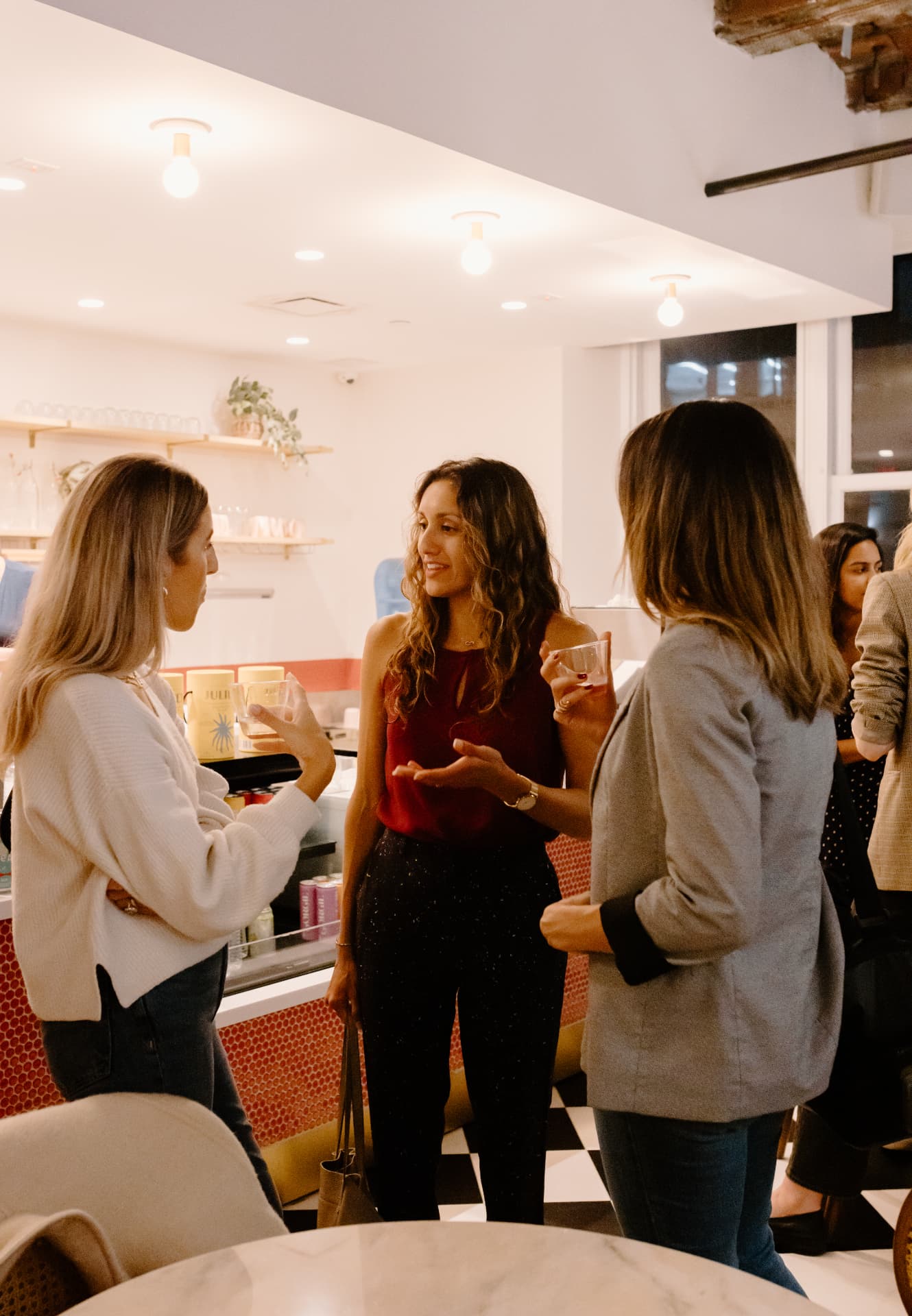 Three women members talking together at a Her Workplace event