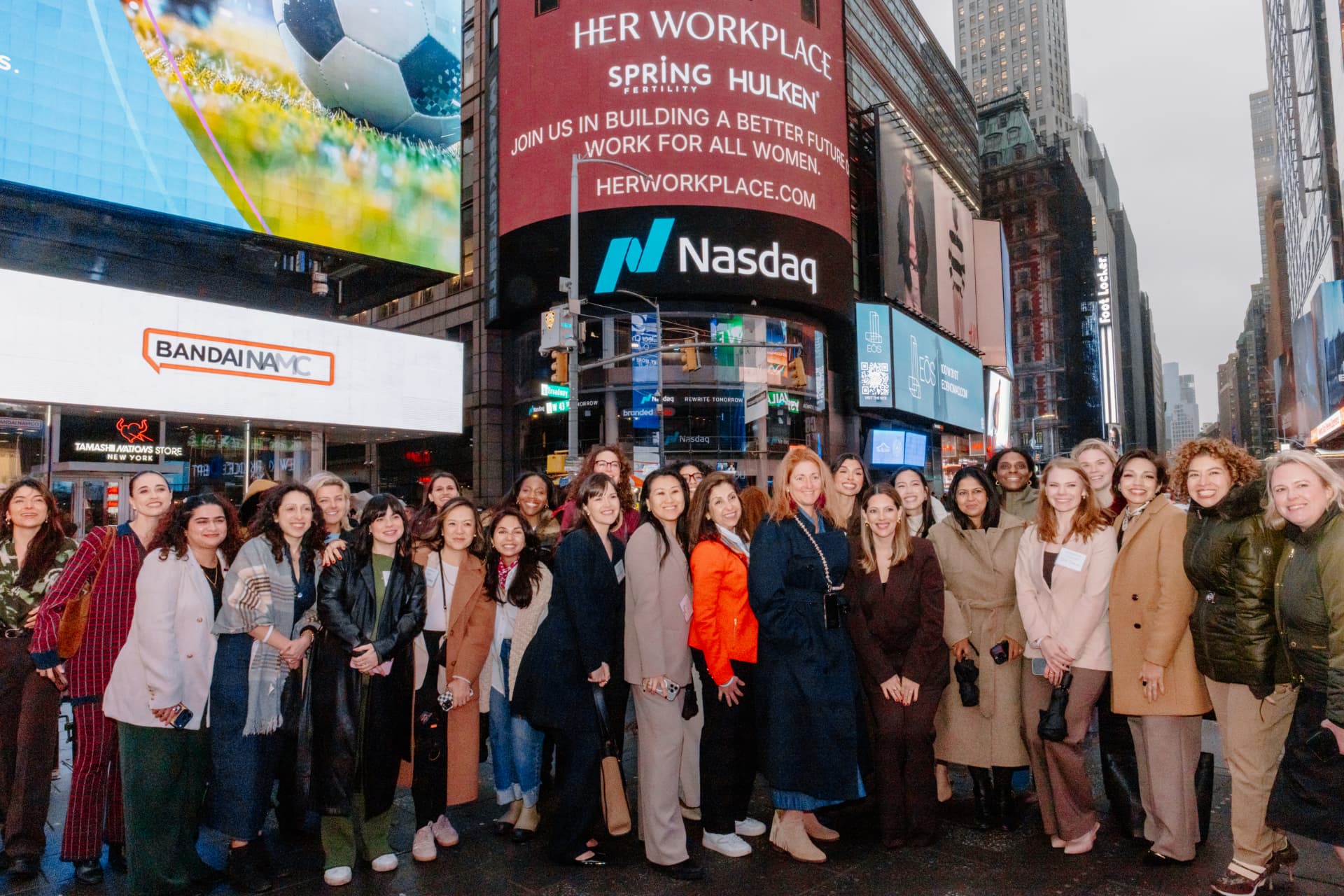 Her Workplace members gathered in Times Square in front of the Nasdaq billboard